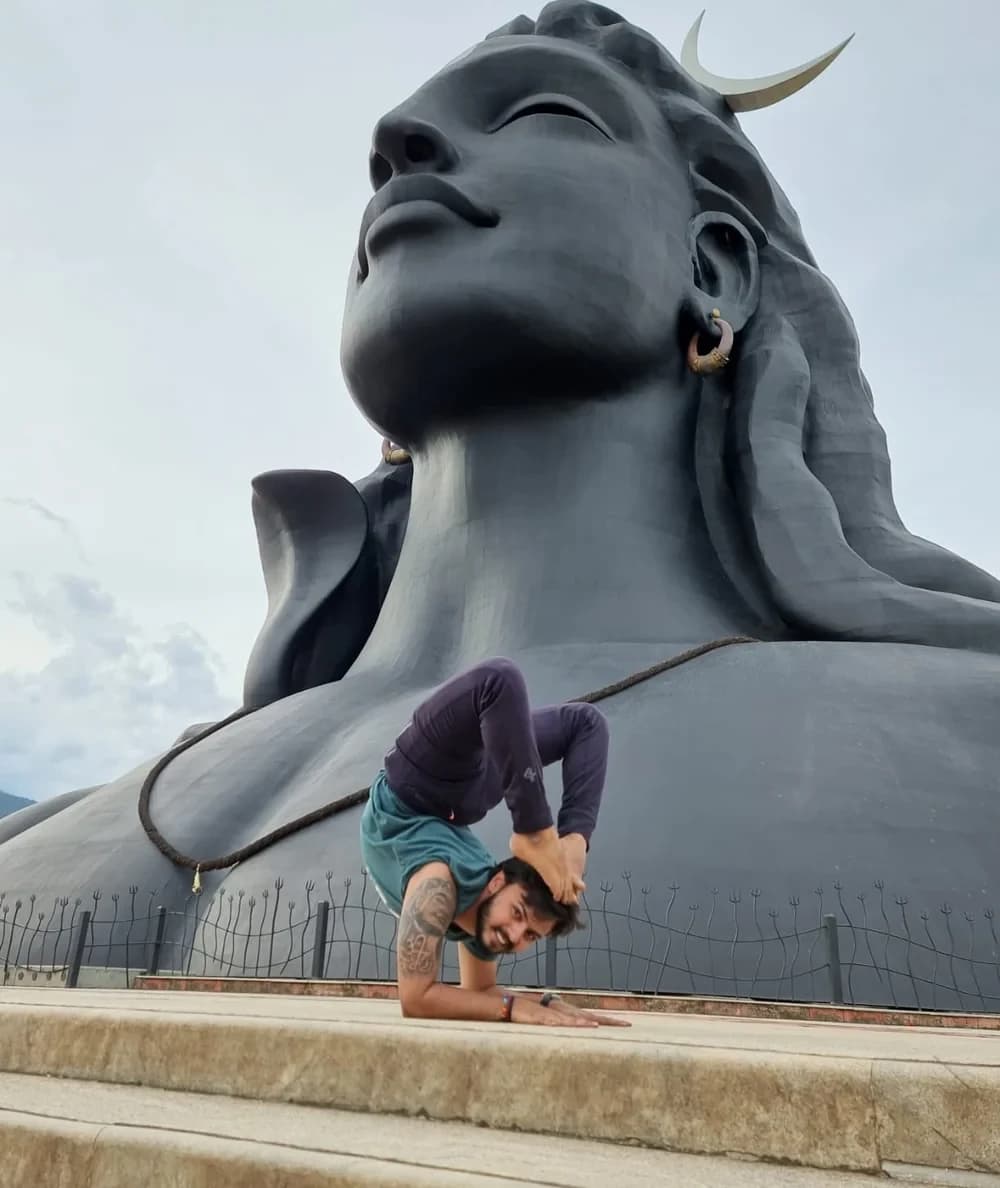 Gandharva in a yoga pose before the Adiyogi Shiva statue