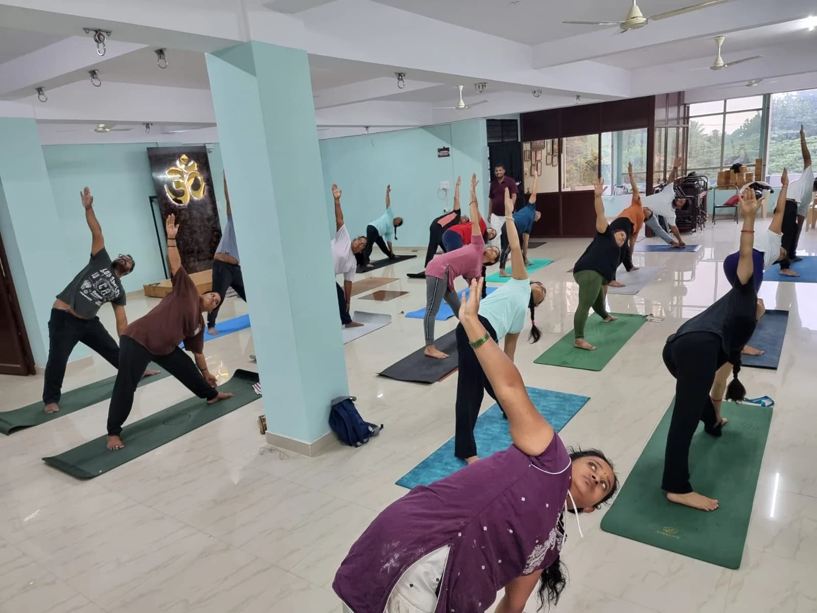Students in extended side-angle pose in natural window light