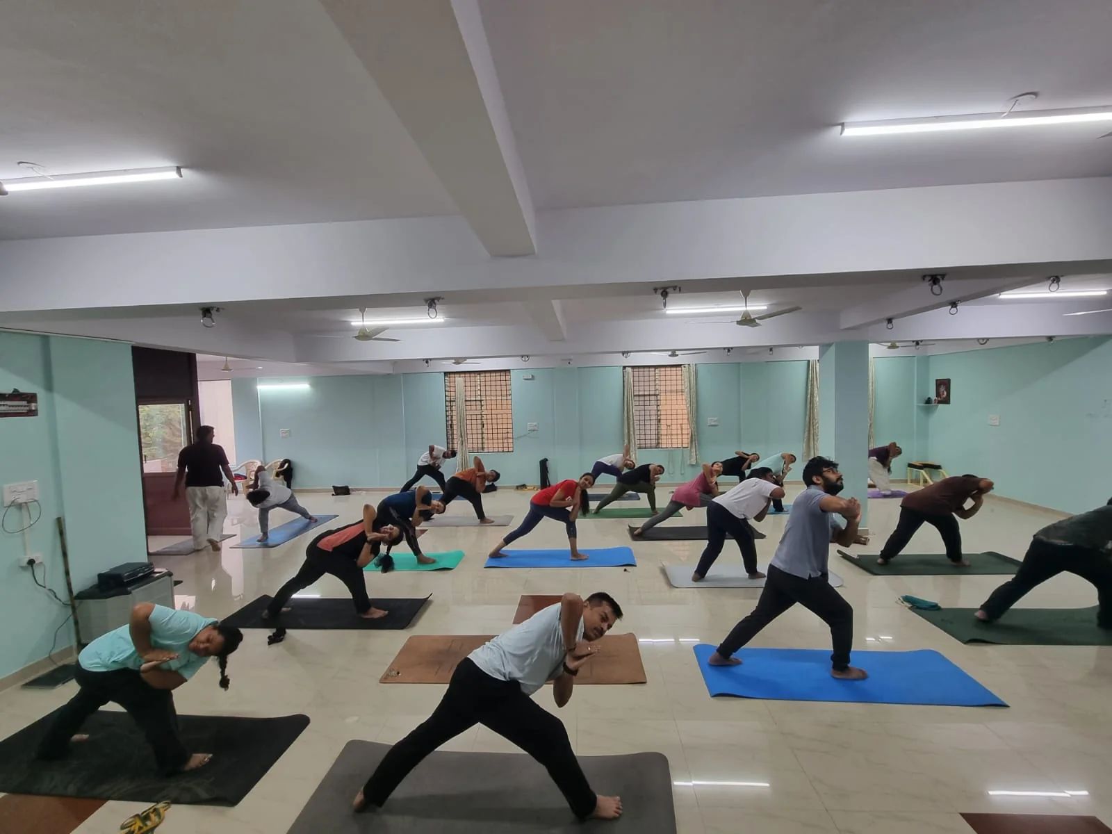 Students in casual clothes holding a warrior twist