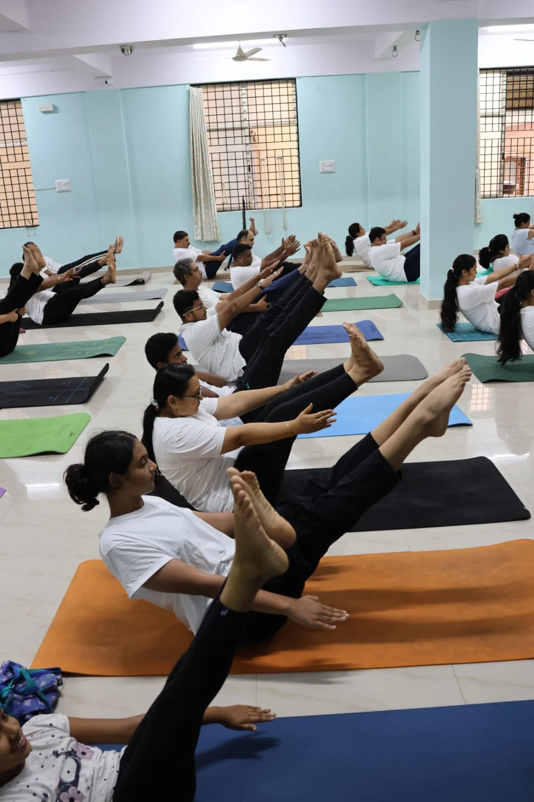 A row of students holding boat pose