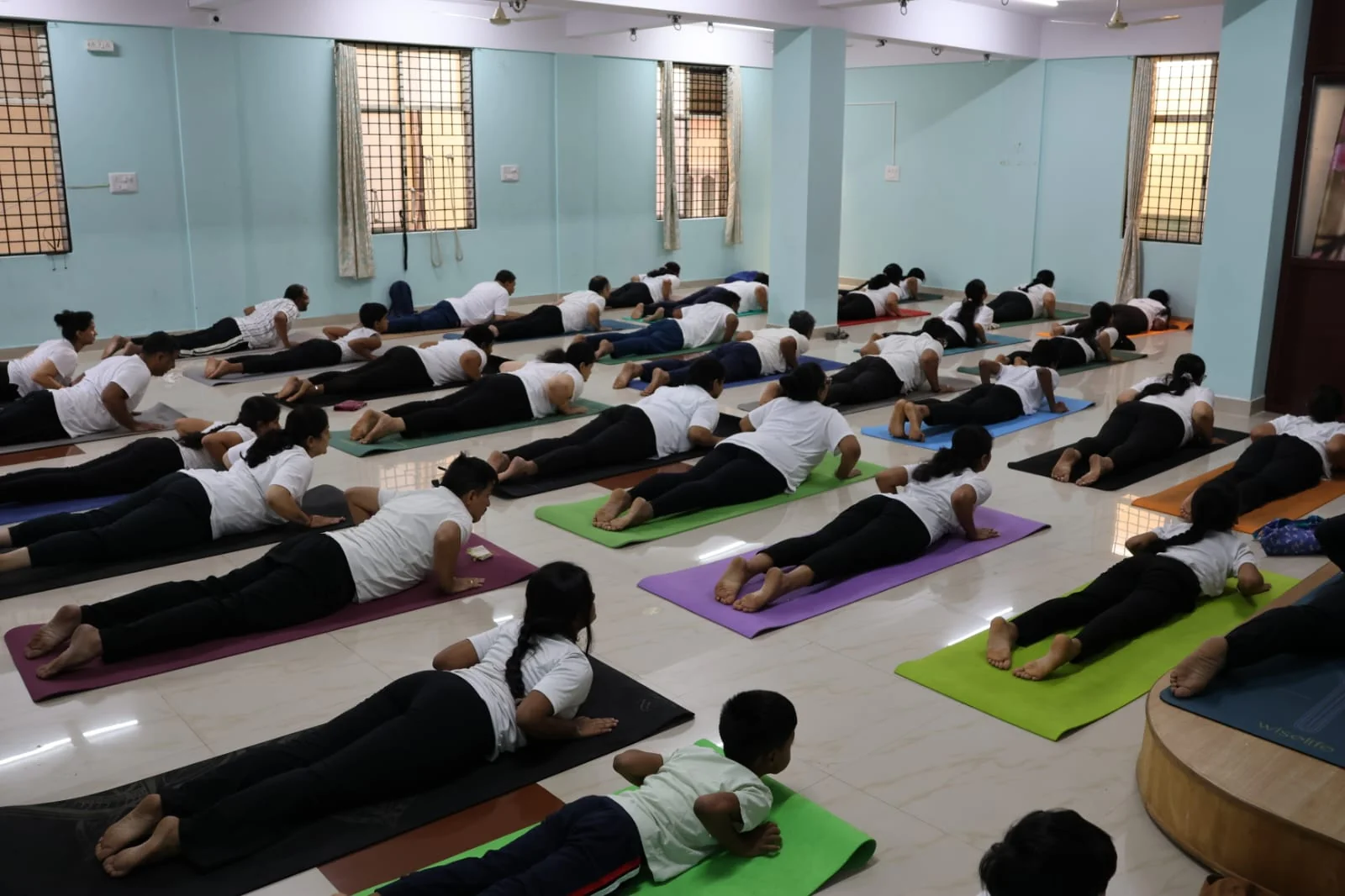 A young boy in cobra pose in the foreground of a class